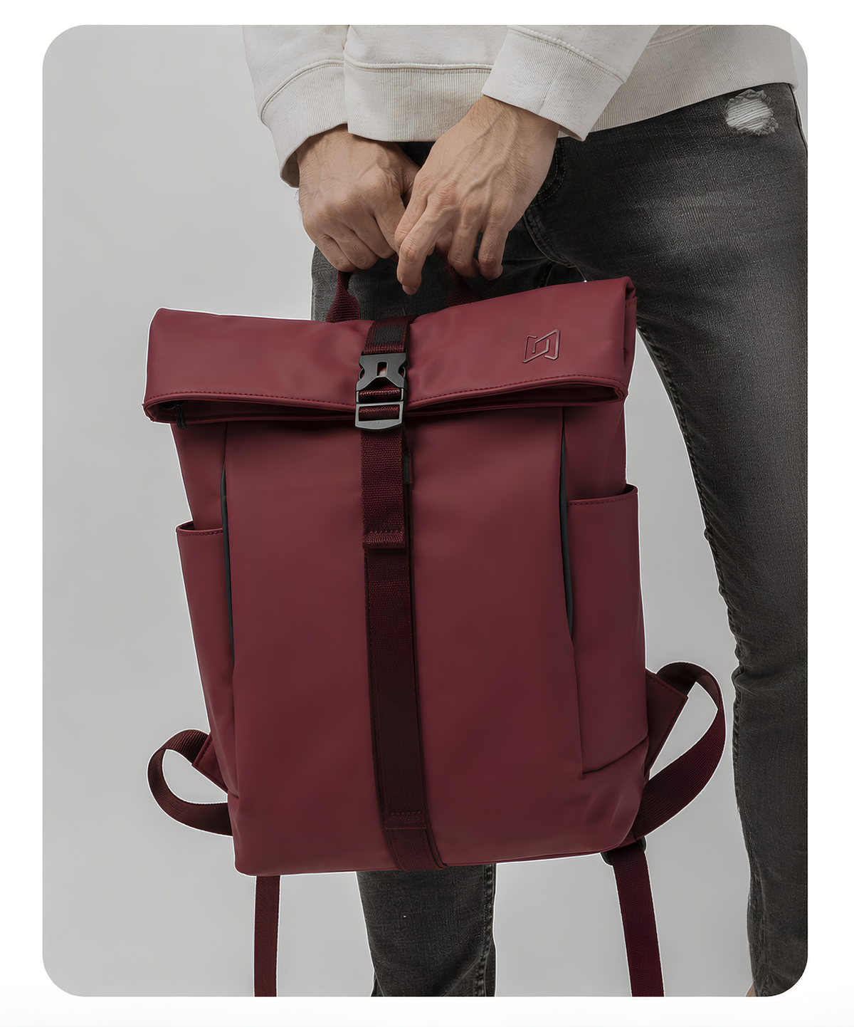 The Outpost Roll-Top Backpack in Burgundy carried by hand #Color_Burgundy