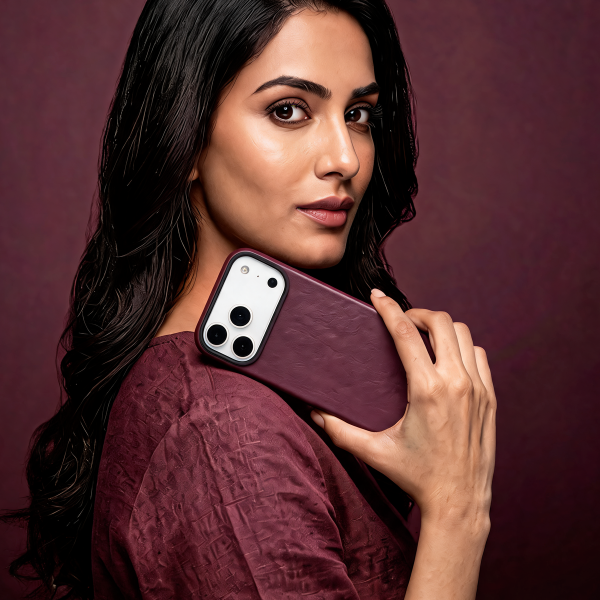 Muvtech Siena Leather-Finish Case for iPhone 18 Pro in Burgundy, held by a model