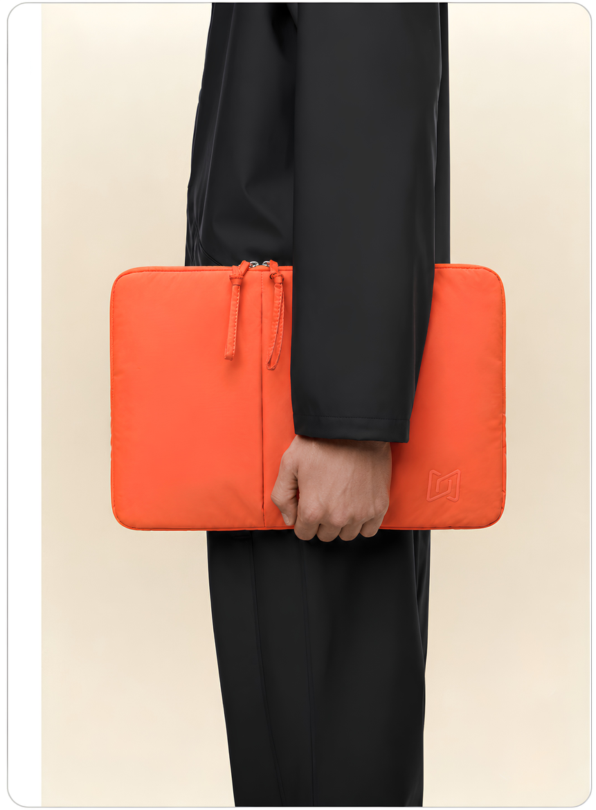 The Port Laptop Sleeve in Orange carried in hand #Color_Orange